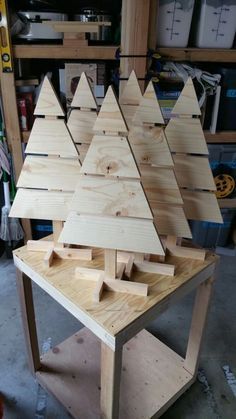 a wooden christmas tree sitting on top of a table in a room filled with tools