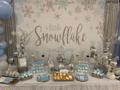 a snowflake themed dessert table with blue and silver decorations