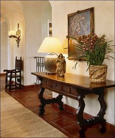 a table with two vases on top of it next to a lamp