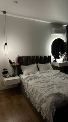 a large bed sitting in a bedroom next to a night stand with flowers on it