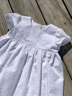 "Dress runs true to size. The dress has button closure in the back. The listing is for one dress. Made to order. These dresses has an average fit around the bust, measure your child around the bust and add 1-2\" for ease and choose the size closest. Size Chest Length 0-3m 17.5\" 13\" 3-6m 18.5\" 14\" 6-12m 19.5\" 16\" 12-18m 20.5\" 17.5\" 18-24m 21\" 19\" 2t 21.5\" 20\" 3t 22.5\" 21\" 4t 23.5\" 22\" 5y 24.1/4\" 23\" 6y 25.1/4\" 24\" 7y 26.5\" 25\" 8y 27 3/4\" 27 designer eyelet cotton, 100% DETA Fitted Flutter Sleeve Dress For Baptism, Fitted Flutter Sleeve Baptism Dress, Cute Fitted Dress For First Communion, Elegant Short Sleeve First Communion Summer Dress, Spring Baptism Dress With Broderie Anglaise, Elegant Cotton Baptism Dress With Broderie Anglaise, Classic Short Sleeve Dress For Baptism, Fitted Cute Baptism Dress, Cute Fitted Baptism Dress