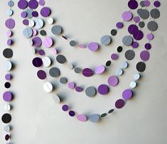 a white wall with purple and grey circles on it, hanging from the side of it