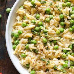 a white bowl filled with pasta and peas