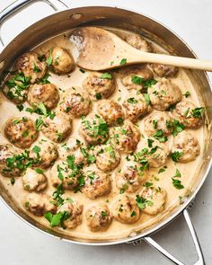 a pan filled with meatballs covered in gravy and garnished with parsley