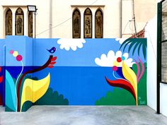 a colorful mural on the side of a building in front of a gated entrance