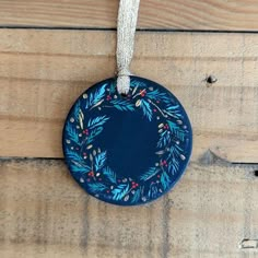 a blue ornament hanging on a wooden wall with a string attached to it