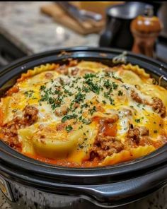 a crock pot filled with meat and cheese