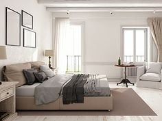 a bedroom with white walls and wood floors