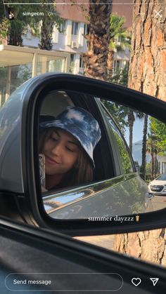 a woman is seen in the side mirror of a car