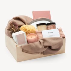 a wooden box with candles, soaps and other items in it on a white background