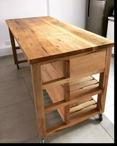 a kitchen island made out of wood with wheels on the bottom and drawers underneath it