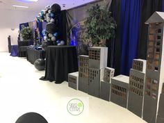 a room with black and white decorations on the walls, blue drapes, and balloons