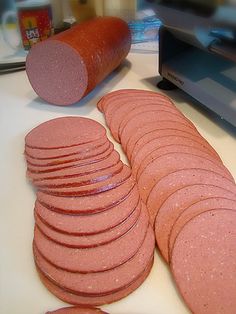 a pile of pink cookies sitting next to a laptop