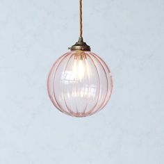 a light that is hanging from a wire on the ceiling with a white wall in the background