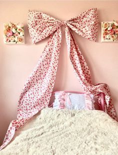 there is a pink wall with two bows on the top and one bow at the bottom