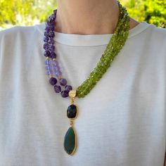 Real amethyst and raw peridot beaded necklace with long pendant. Chunky statement natural gemstone layered beaded necklace for women. Large purple green gold handmade necklace with big bead and gemstone. Big bold bohemian bright necklace in gold color are suitable for an casual look, evening look and for a holiday. These necklace will be a good Christmas, anniversary, wedding or birthday gift for women, mom, wife, girlfriend, sister or daughter. Women's necklace with natural stone. It emphasizes the beauty of your neck and adds charm to your look. FAST FREE SHIPPING EARRINGS AS A GIFT You can see even more necklace here.   https://www.etsy.com/shop/VesnekaJewelry?ref=seller-platform-mcnav§ion_id=40601375 Dimensions: The necklace has a length of 50 centimeters. Structure: Amethyst, raw peri Spiritual Peridot Jewelry With Gemstone Accents, Spiritual Peridot Jewelry With Gemstone, Spiritual Peridot Gemstone Jewelry, Multi-strand Gemstone Jewelry For Layering, Double Strand Amethyst Gemstone Beads Jewelry, Purple Double Strand Jewelry With Natural Stones, Double Strand Purple Jewelry With Natural Stones, Long Gemstone Necklace For Layering, Purple Double Strand Natural Stones Jewelry