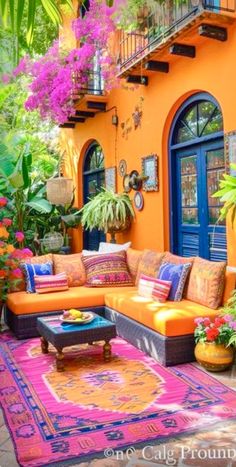 an outdoor living room with orange couches and colorful rugs