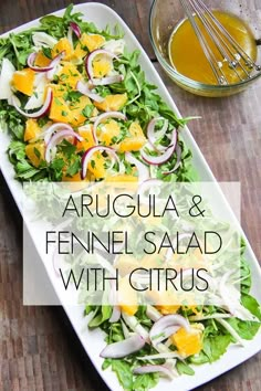 arugula and fennel salad with citrus dressing on a platter next to a whisk of olive oil