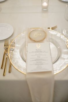 the table is set with white and gold place settings