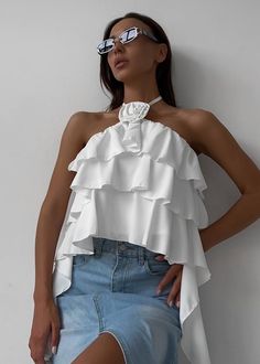 This luxurious Halter 3D Flower Detail Ruffled Crop Top will add unique sophistication to any wardrobe. Crafted with delicate ruffles and detailed with floral, this halter-style peplum top exudes opulence and elegance. Enjoy the perfect combination of charm and comfort. Fabric: Polyester Chic Ruffled Halter Top For Summer, Chic Party Tops With Ruffle Hem, Chic Tops With Ruffle Hem For Party, Feminine Ruffled Halter Top For Summer, Summer Party Halter Top With Ruffles, Feminine Party Tops With Ruffles, Glamorous Halter Neck Tops For Summer, Glamorous Halter Neck Summer Top, Feminine Ruffled Sleeveless Halter Top