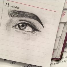 a pencil drawing of an eye on top of lined notebooks with the words 21 sunday written below it