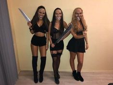 three women dressed in costumes holding knives and smiling