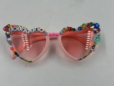 a pair of sunglasses with beads and letters on them