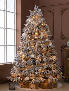 a white christmas tree with presents under it