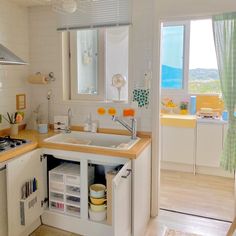 a kitchen with a sink, dishwasher and stove top oven next to a window