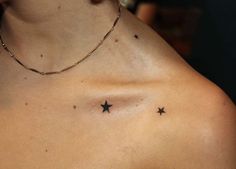 a woman's chest with three stars tattooed on the left side of her chest