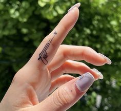 a woman's hand with a small tattoo on her left thumb, and the word love written in it