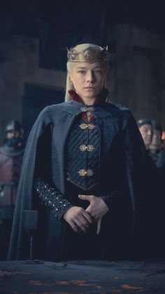 game of thrones character daener merly dressed in black and gold armor, standing with his hands on his hips