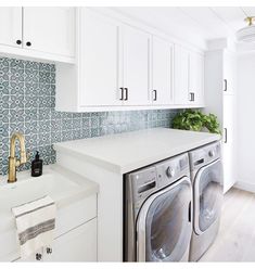 a washer and dryer in a white kitchen with blue tile backsplash