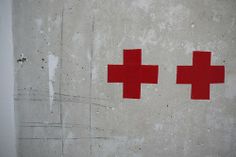 two red crosses painted on the side of a cement wall