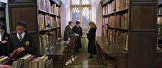 people are standing in a library with many books