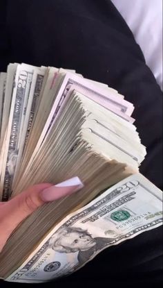 a person holding stacks of money in their hand