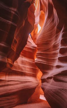 a narrow slot in the side of a canyon with light coming from it's windows