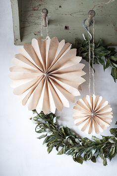 two paper fans hanging from the side of a wall