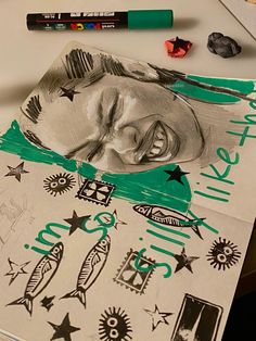 a drawing of a man's face on top of a piece of paper next to crayons and markers