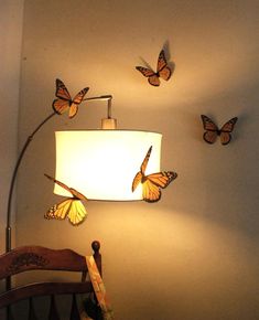 a lamp that is on top of a table next to a chair and some butterflies