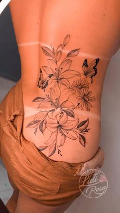 a woman's stomach with flowers and butterflies on the side, showing her lower back