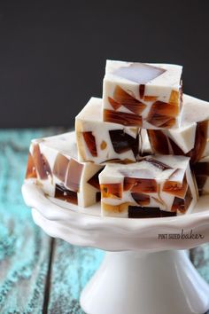 pieces of caramel and white chocolate fudge on a cake plate with blue background