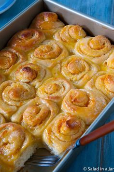 a pan filled with cinnamon rolls on top of a blue table