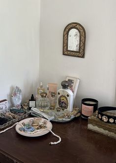 a wooden table topped with assorted items on it's sideboard next to a mirror