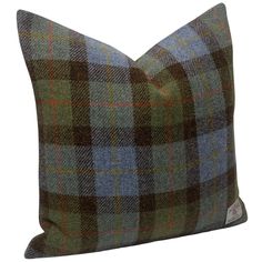 a green and blue plaid pillow on a white background