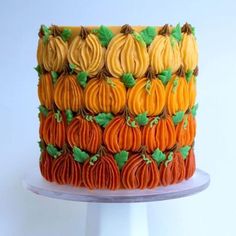 there is a cake decorated with pumpkins on the top and green leaves on the bottom