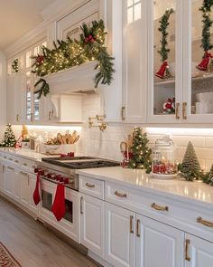 a kitchen with white cabinets and christmas decorations