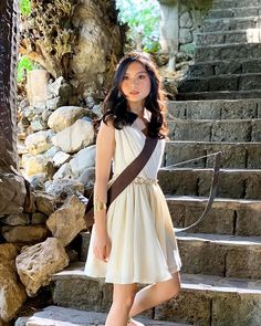 a woman in a dress standing on some steps