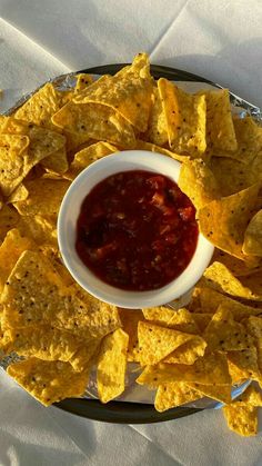 tortilla chips with salsa and ketchup in a bowl on a plate