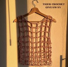 a crochet top hanging on a wall with the words tiger crochet giveaway written below it